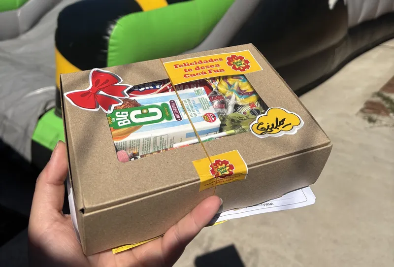 Caja de regalo de Cucú Fun para el cumpleañero frente a un inflable